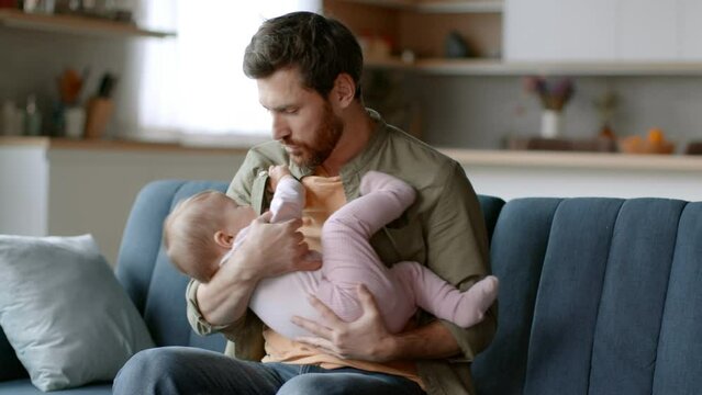 Fatherhood difficulties. Desperate father trying to calm down his crying baby daughter, little girl screaming,free space