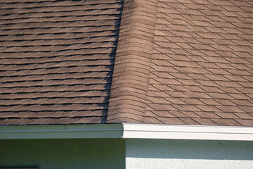 Closeup of house roof top covered with asphalt or bitumen shingles. Waterproofing of new building