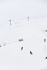 cable car are move on snowy mountain with skiers top view