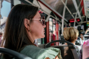Woman rides to work in bus sitting on seat and looking out window. Problem of work schedule of...