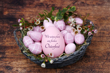 Grußkarte Frohe Ostern: Osternest mit rosa Ostereiern und einem beschrifteten Osterei.