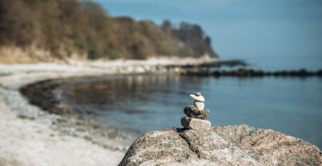 Steinturm, Steine am Strand vor Meer und blauem Himmel