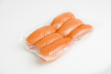 Raw sausages in a polyethylene casing in a transparent package on a white background. View from...