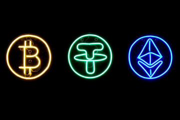 Close-up of neon signs in the form of logos of famous crypto-currencies on a dark background