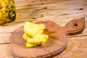 Cutting board with sliced pineapple on wooden table