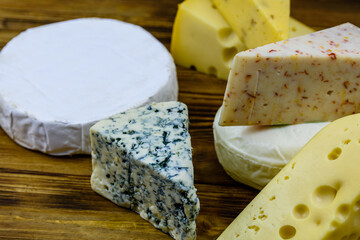 Various types of cheese on a wooden background