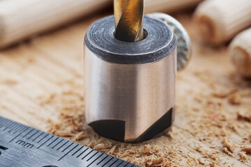 Obraz na płótnie Canvas Countersink drill bit with steel triangle ruler make sink in hole for screw in wooden oak plank
