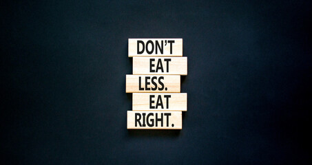 Eat less or right symbol. Concept words Do not eat less, eat right on wooden blocks. Beautiful black table black background. Healthy lifestyle and eat less or right concept. Copy space.