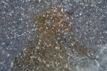 Cracks and air bubbles in the ice of the lake.