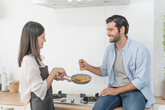 Happy young couple cooking together in the kitchen at home