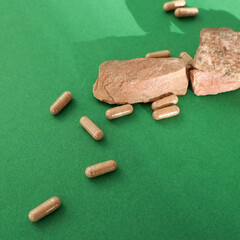 Brown pills and stones on a green background. Medicine. Health, beauty. High quality photo