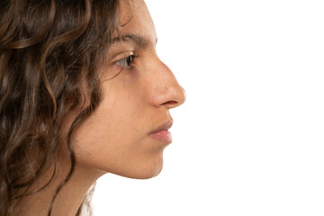 Profile portrait of a beautiful serious young woman, a nose with a hump on white background