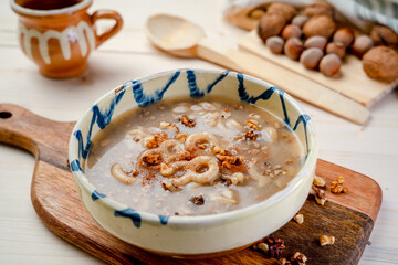Romania traditional food desert Macinici or Mucenici on traditional plate and white wood table