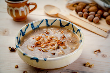 Romania traditional food desert Macinici or Mucenici on traditional plate and white wood table