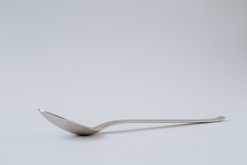 Silver shiny spoon on white background, kitchenware, copy space