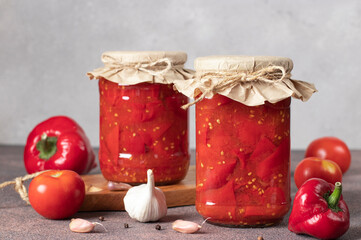 Pickled sweet peppers with tomatoes in two glass jars, Close up