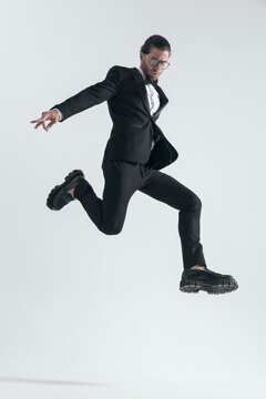 Dynamic Elegant Man In Black Tuxedo Jumping In The Air