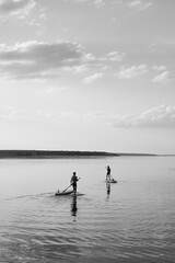 two boys surfing on the lake black and white 