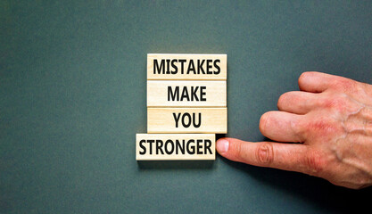 Mistake make stronger symbol. Concept words Mistakes make you stronger on wooden blocks. Beautiful grey table grey background. Businessman hand. Business mistake make stronger concept. Copy space.