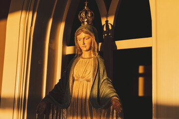 Statue of the Virgin Mary bathed in golden sun