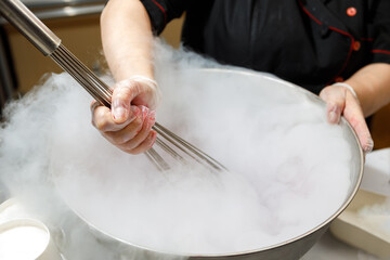 Stirring ice cream frozen with liquid nitrogen in a large cup.
