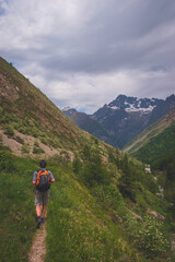 A male hiker walking in the Alps mountains in summer (Valgaudemar valley, Les Oulles du Diable hike)