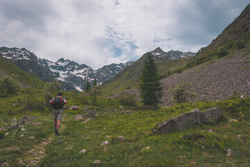 A male hiker walking in the Alps mountains in summer (Valgaudemar valley, Les Oulles du Diable hike)