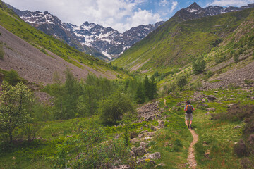 A male hiker walking in the Alps mountains in summer (Valgaudemar valley, Les Oulles du Diable hike)