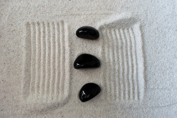 Fototapeta na wymiar black stone in sand 