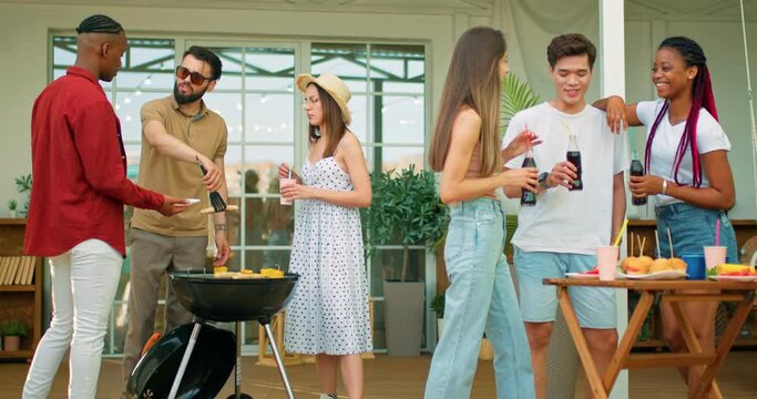 relaxed two diverse women holding bottle of coca cola, holding arm on Asian man shoulder. laughing, chatting, having fun, coworkers celebrating summer holidays, vacation weekend with healthy food