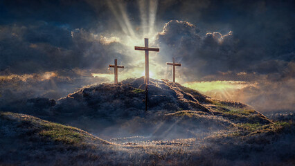 3 Crosses on a hill with sun rays and clouds in the background
