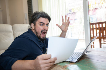 Handsome young man shocked over high bill in office