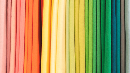 Mix colorful hanging vertical stripe textile, fabrics, cloths on the rack. Texture of multicolored...