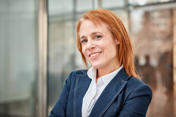 Determined middle-aged businesswoman smiling, building her success story.
