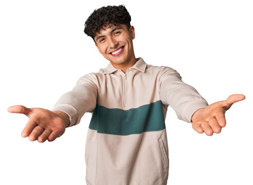 Young latin man pointing with finger at you as if inviting come closer.
