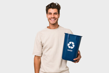 Young caucasian man holding a paper trash for recycle happy, smiling and cheerful.