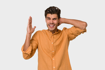 Young handsome caucasian man isolated on white background screaming with rage.