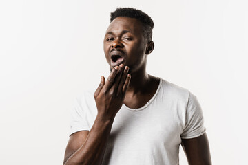 African american man is feeling toothache pain and discomfort of tooth. African man with tooth decay, infection or injury to the tooth or gums on white background.