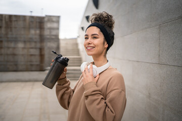 One young woman caucasian female hold supplement shaker outdoor in day