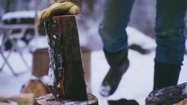 chop wood in winter. Man chopping wood with an axe. Farmer with an axe chopping wood in the barn. 