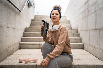 One young woman caucasian female hold supplement shaker outdoor in day