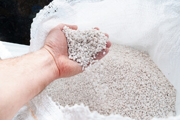 Perlite for plants in the hand. neutral material of volcanic origin