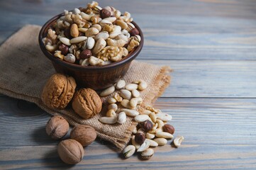 mixed nuts in a bowl on wooden table, top view with copy space.