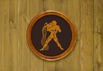The sign of the zodiac Aquarius in a round frame on the wall of the boards