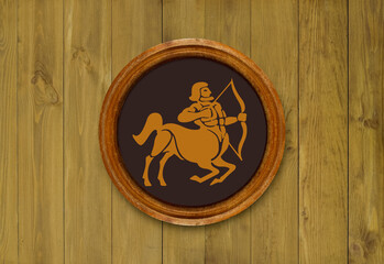 The sign of the zodiac Sagittarius in a round frame on the wall of the boards