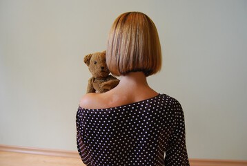 A girl with a teddy bear on her shoulder