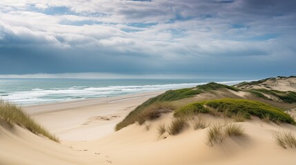 Beautiful sunny sand dunes at the shore. Ocean sea landscape on the beach with calming waves.