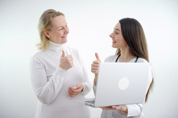 young girl doctor showing thumb up to woman patient woman happy also showing class she is all healthy and happy helped medicines white background good medicine