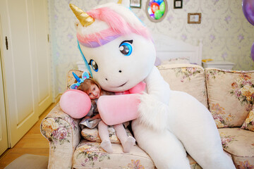  Cute little girl with an animator in a unicorn costume.