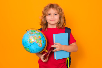 Fototapeta premium Studio portrait of school child. School boy world globe and book. School kid 7-8 years old with book go back to school. Little student. Education concept.
